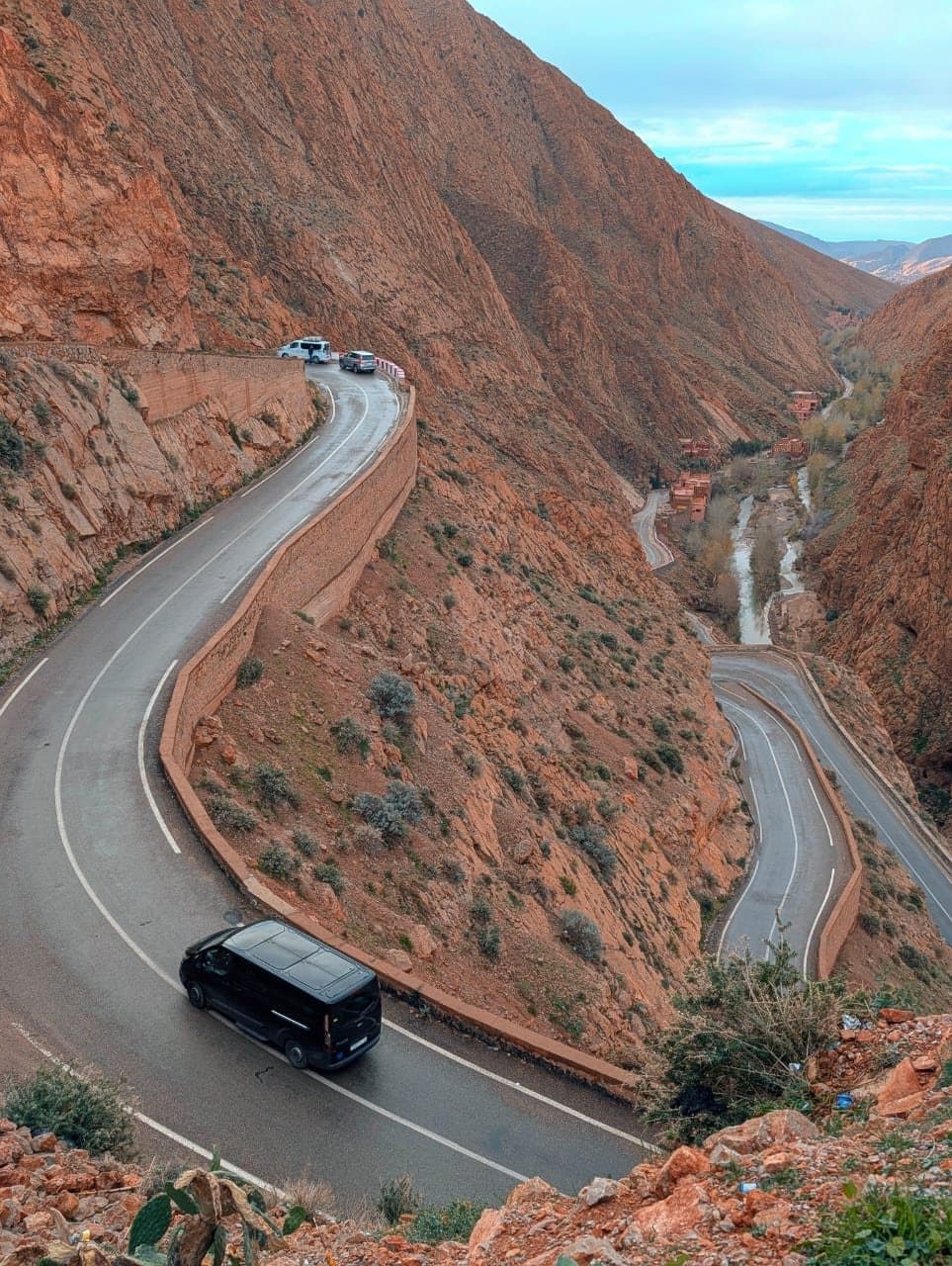 A van on the road that climbs through the Dadès Gorge in hairpin bends, seen from above