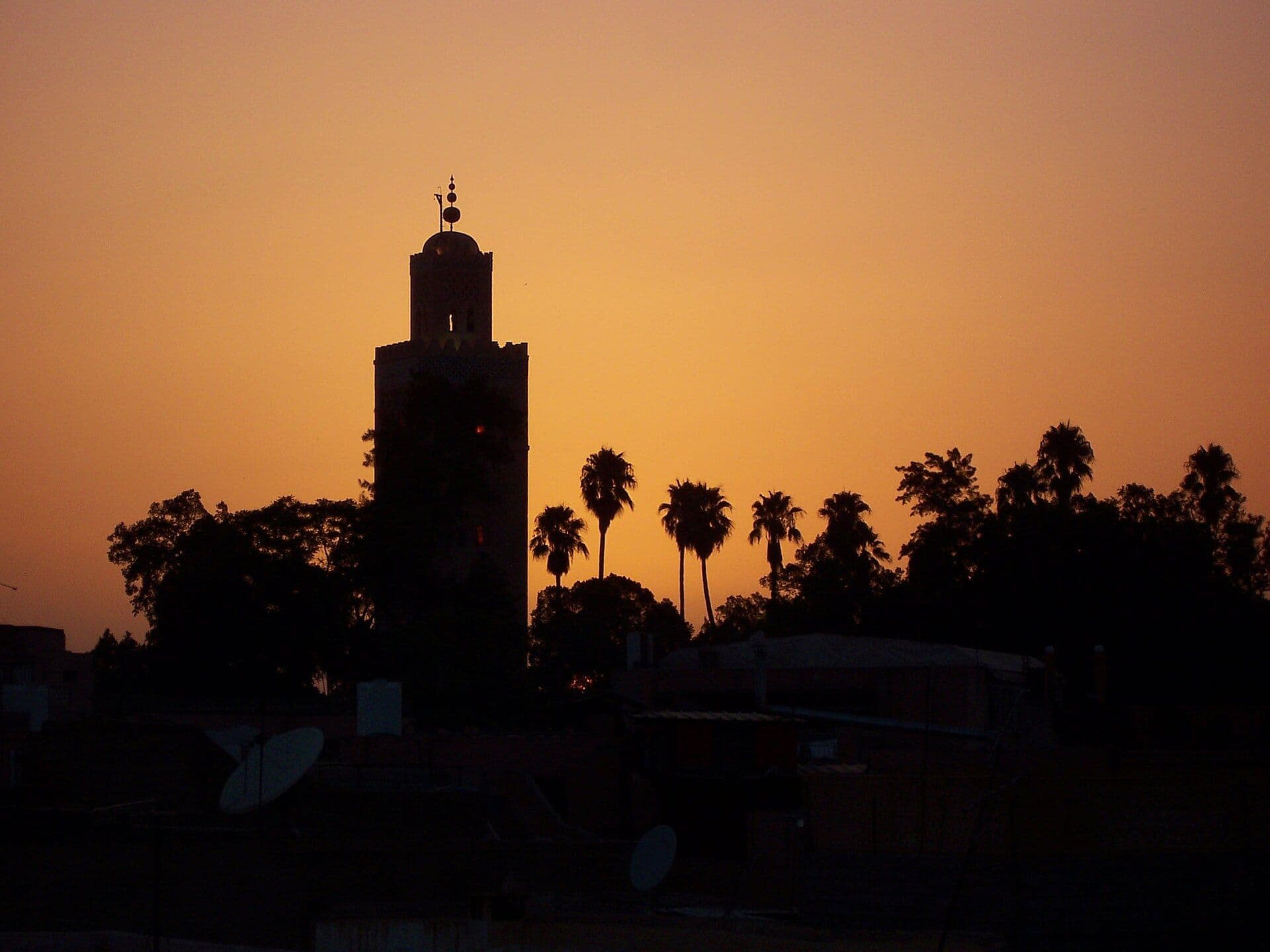 Silhouette of the Koutoubia minaret in Marrakesh against an orange evening sky