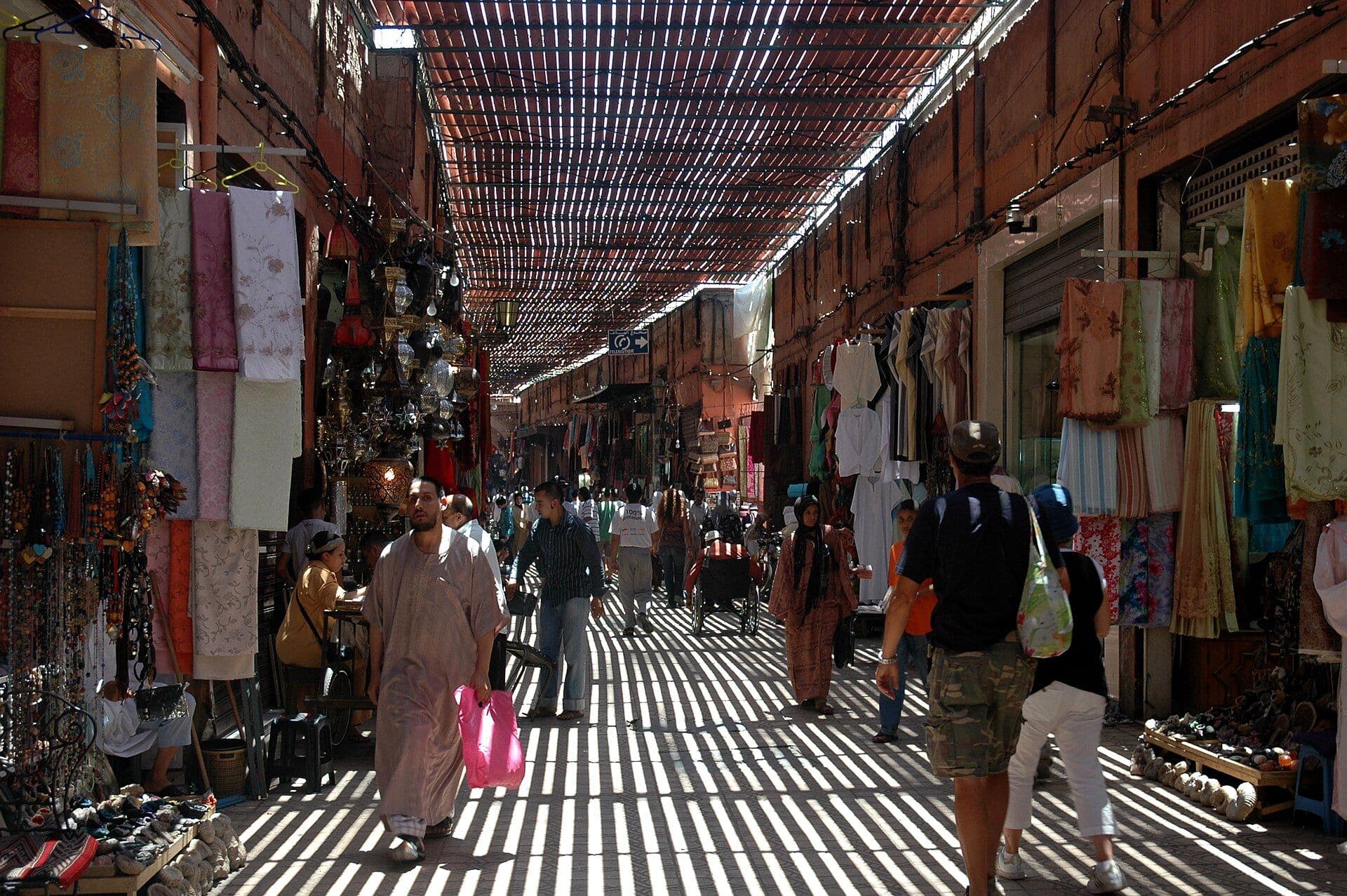 Covered souk in Marrakesh with stripes of sunlight coming through the reed roof