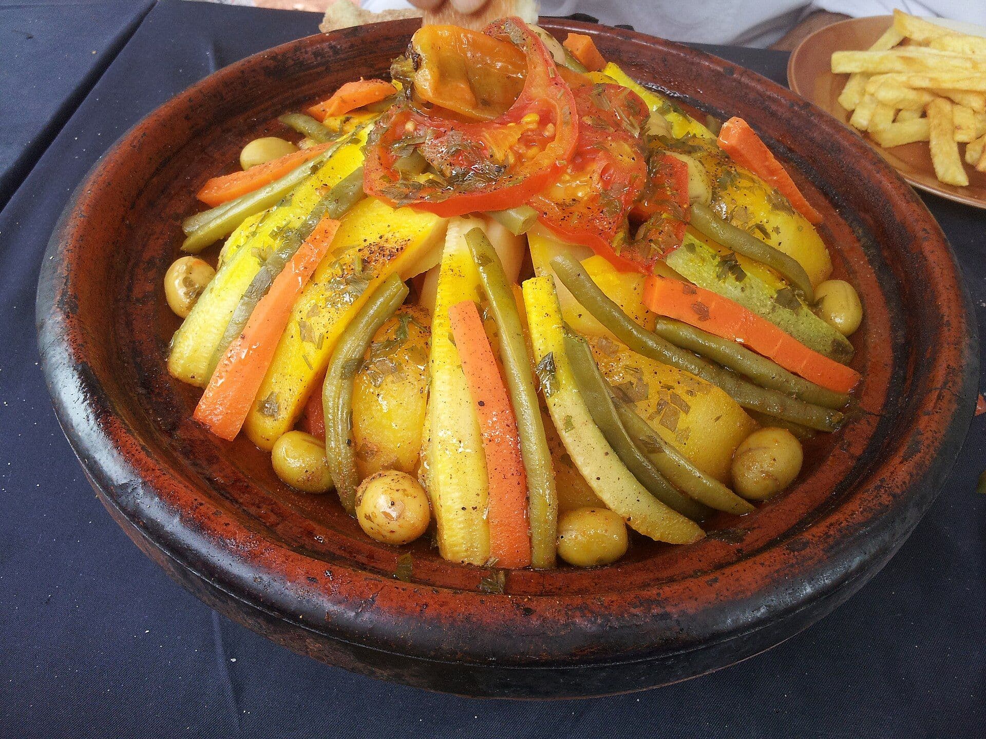 Vegetable tagine with carrot, zucchini and olives in an earthenware dish